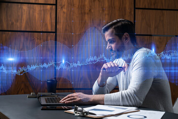 A serious caucasian analyst in casual wears, using laptop to proceed the forecast of stock market behavior. Double exposure. Forex Hologram. Concept of internet trading.