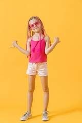 Fototapeta na wymiar Stylish girl with pink dreadlocks and posing on a yellow backgro