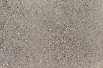 Grey asphalt with scratches and damages sunny day Background