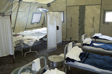 Obraz na płótnie Canvas inside a tent mobile military hospital, empty beds