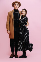 Portrait of a unique young couple. Man is serious, woman is playing cute