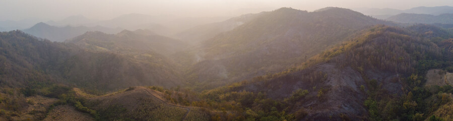 Beautiful yellow mountain landscape with fog and forest. sunrise in mountains, Wildfire in the mountains.