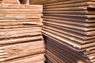Close-up large cardboard piles lie on top of each other in a warehouse. Concept of storage of things and environmentally friendly material. Renewable material concept