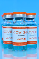 Covid-19 vaccine in glass bottles on table.