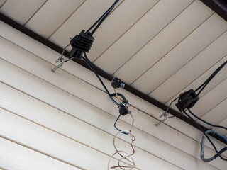inserting electrical cables into a wooden house through the air with the help of piercing hermetic clamps