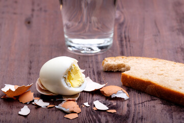 peeled egg and bitten off piece of bread, selective focus on the egg