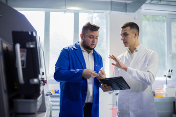 Engineer and technician discussing production process at factory