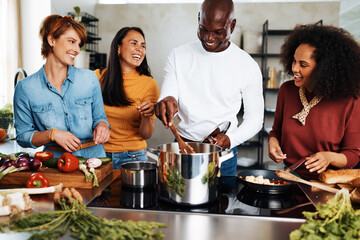 Diverse friends cooking together - Powered by Adobe