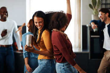 Laughing friends dancing in a kitchen