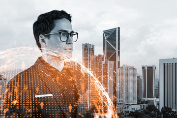 Handsome eastern HR director at international company thinking about efficient strategy to recruit highly qualified specialists. Social media and marketing hologram icons over Kuala Lumpur background