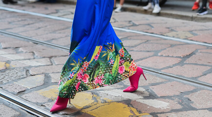 Detail of a fashionable outfit – woman wearing colorful dress and pink shoes