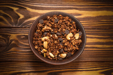 Chocolate granola cereal with nuts in a bowl.