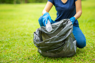 Save the world concept,volunteers carry water bottles,plastic bags that have fallen in the park put them in trash,Environmental protection,volunteering for charity,Waste disposal through recycling.