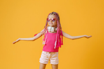 Trendy DJ girl in bright clothes, headphones and bright dreadloc