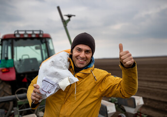 Farmer carrying seeds for sowing in sack on shoulder