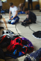 Details of parachute equipment on the background of skydivers packing parachutes before jumping.