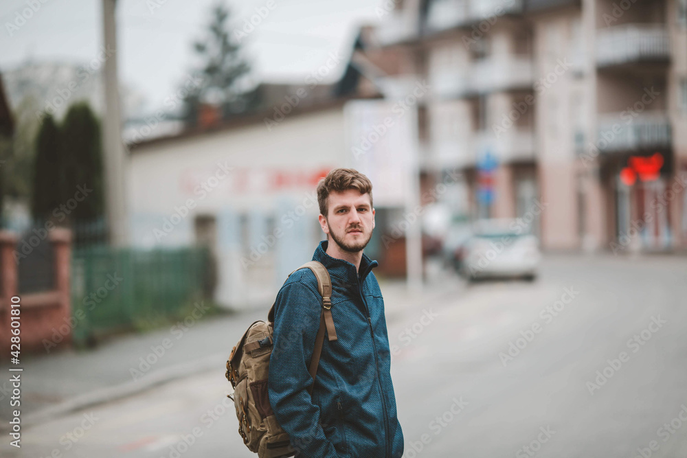 Poster Shallow focus shot of a young caucasian man standing on a street