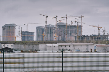 Naklejka premium New high-rise reinforced concrete houses under construction. Construction cranes. Kiev, Ukraine.
