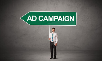 Young business person in casual holding road sign