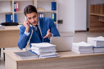 Young businessman employee and too much work in the office