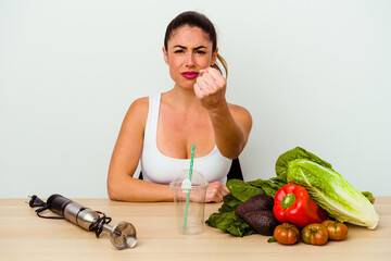 Young caucasian woman preparing a healthy smoothie with vegetables