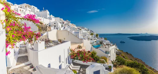 Poster Summer vacation panorama, luxury famous Europe destination. White architecture in Santorini island, Greece. Travel landscape cityscape with pink flowers, stairs, caldera view in sunlight and blue sky © icemanphotos
