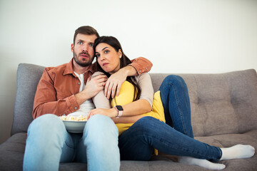 Fototapeta na wymiar Man and woman watching horror movie at home