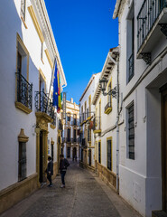 cute and narrow streets with white facades of the old town of Ronda, a town located in Andalusia, Spain
