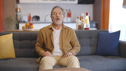 Breathing deeply at home, the old man breathes peacefully and yawns. Breath at home concept. Breath...