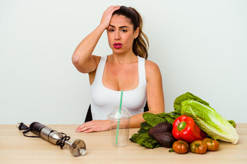 Young caucasian woman preparing a healthy smoothie with vegetables