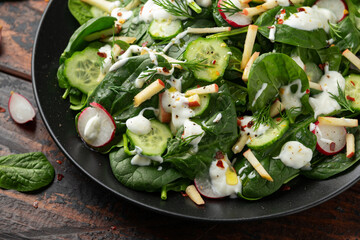Fresh cucumber radish apple salad with spinach, dill and yogurt dressing. Healthy food