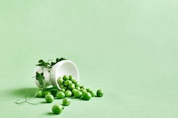 Minimal food creative concept. Fresh green peas on light green pastel background.