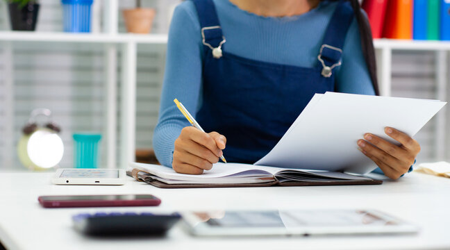 A woman doing a personal account book. Female university students writing homework for academic projects.