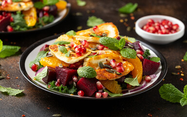 Fried Halloumi Cheese salad with beetroot, orange, pomegranate and pumpkin seeds, red onion, green vegetables. healthy food