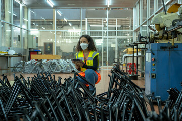 Engineer women wearing protection face mask are working and checking product in small industrial...