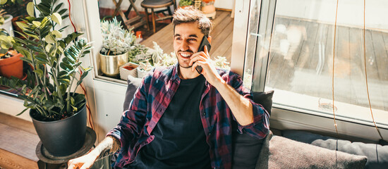 Young man with laptop and smartphone at home. Freelancer. Concept of remote work or study.