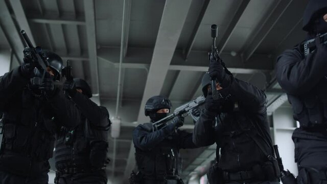 Special ops police team protecting urban building with assault rifles