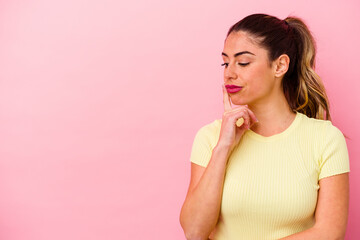 Fototapeta premium Young caucasian woman isolated on pink background