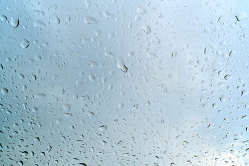 Raindrops on the windshield of a car, shallow depth of field. The texture of raindrops on the glass.