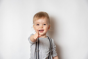 A little child shows a finger forward on a white background.