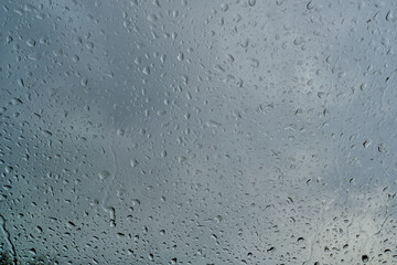 Raindrops on the windshield of a car, shallow depth of field. The texture of raindrops on the glass.