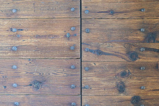 Top view of rich wooden planks with nails in them and a line in the middle separating them