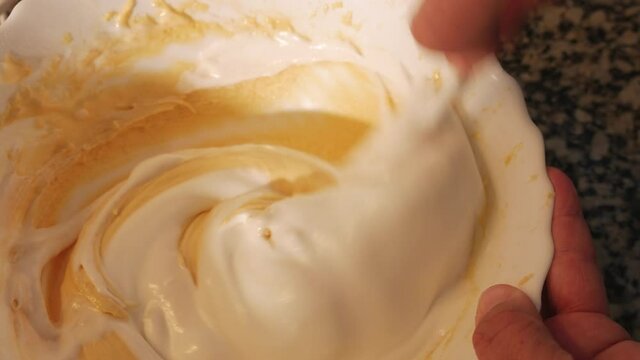 Hand kneading the dough with a spoon, extreme close up