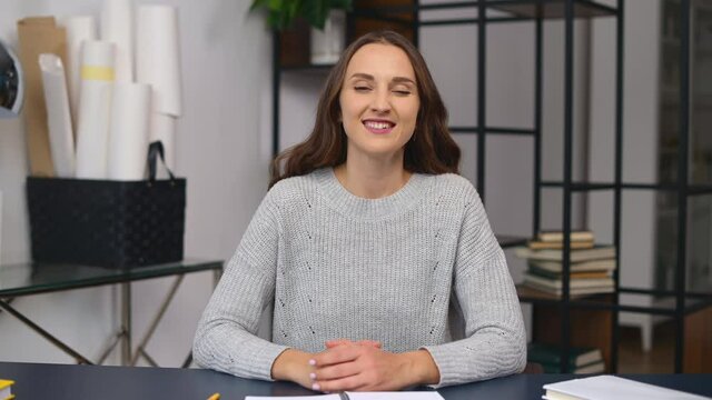 Online job interview concept. Video chat with a smiling young woman in casual wear, a female job seeker introducing herself on the distance. A colleague looks at the camera and talking, video call