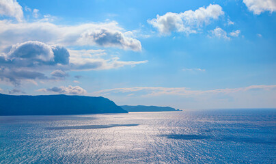 Amazing blue mountains over the blue sea, gorgeous clouds in the background