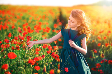 beautiful girl in poppy field enjoys the beauty and aromas.