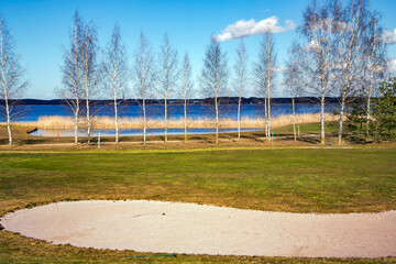 Obraz premium Golf place with gorgeous green and nice Kisezers lake view in Riga, Latvia 