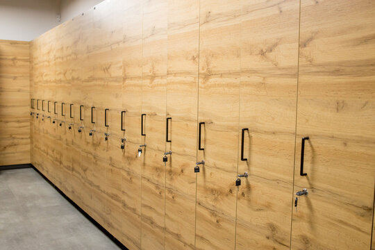 Wooden locker boxes, with metal locks. Classic wood locker room and a bench