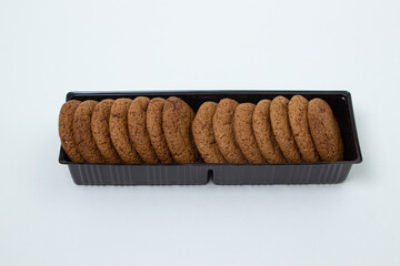 Oatmeal cookies in a plastic container on a white background. Diet food. Light breakfast