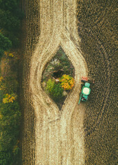 A large harvester collects corn in the field. View from above.